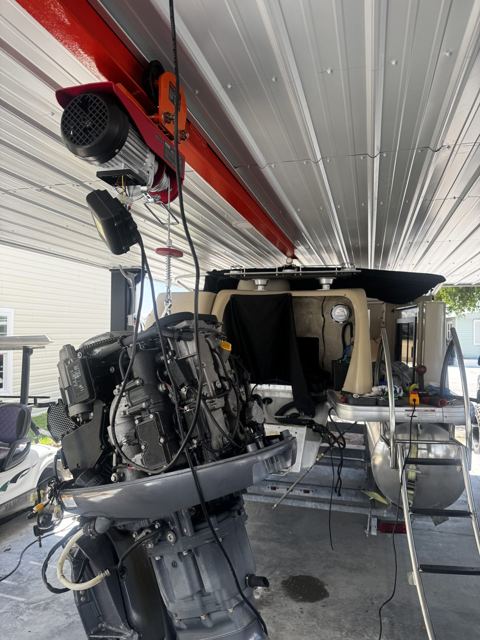 Outboard on the hoist in the shop